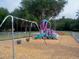 Fenced playground with a playset including swings, a slide, and climbing area on a wood chip surface at 22777 Sw Surf Blvd, Dunnellon, FL 34431