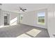 Spacious bedroom with gray carpet, ceiling fan, and large windows at 24300 Sw Sea Cliff Ave, Dunnellon, FL 34431