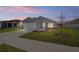 House exterior at dusk with driveway and lawn at 24300 Sw Sea Cliff Ave, Dunnellon, FL 34431