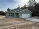 New construction home with light green exterior and white garage door at 24300 Sw Sea Cliff Ave, Dunnellon, FL 34431