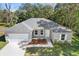 Single-story house with gray roof, white garage door, and landscaped yard at 281 Marion Oaks Crse, Ocala, FL 34473