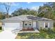 One-story house with gray siding, white garage door, and landscaped front yard at 281 Marion Oaks Crse, Ocala, FL 34473