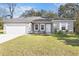 New single-story home with a gray exterior, white garage door, and landscaped lawn at 281 Marion Oaks Crse, Ocala, FL 34473