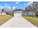 Newly built home with gray siding, white garage door, and a long driveway at 281 Marion Oaks Crse, Ocala, FL 34473