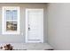 White front door with gray siding and a single window at 281 Marion Oaks Crse, Ocala, FL 34473