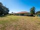 Spacious backyard with grassy lawn and partial view of house at 3333 Nw 47Th Ct, Ocala, FL 34482