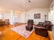 Spacious living room with hardwood floors, leather furniture, and a ceiling fan at 3333 Nw 47Th Ct, Ocala, FL 34482