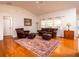 Spacious living room with hardwood floors, leather furniture, and a ceiling fan at 3333 Nw 47Th Ct, Ocala, FL 34482