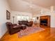Spacious living room with hardwood floors, leather furniture, and a ceiling fan at 3333 Nw 47Th Ct, Ocala, FL 34482