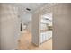 Hallway view of the open-concept kitchen with white cabinets and the bright living room at 3856 Ne 19Th Street Cir, Ocala, FL 34470