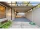 View of a covered patio with gray carpet, and garden plants visible near the border at 3856 Ne 19Th Street Cir, Ocala, FL 34470