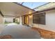 View of a covered patio with neutral decor and sliding glass door to the interior of the home at 3856 Ne 19Th Street Cir, Ocala, FL 34470