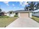 Single-story house with a light green exterior and a tan garage door at 4069 Sw 130Th Pl, Ocala, FL 34473