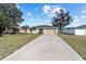 Charming single-story home with a well-maintained lawn, a long driveway, and an attached two-car garage at 4069 Sw 130Th Pl, Ocala, FL 34473