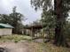 Backyard with wooden covered patio and large tree at 5473 Nw 62Nd Pl, Ocala, FL 34482