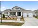 Two-story home with a front porch, two-car garage, and landscaped yard at 6115 Sw 74Th Ct, Ocala, FL 34474