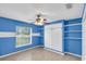 Bright bedroom with blue walls, built-in shelving, and light wood flooring at 7043 Hemlock Crse, Ocala, FL 34472