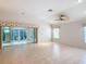 Bright living room with tile floors, vaulted ceiling, and sliding glass doors to the patio at 7824 Se 166Th Smallwood Pl, The Villages, FL 32162