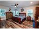 Primary bedroom with rustic wooden bed frame and ceiling fan at 14515 Ne 110Th Avenue Rd, Fort Mc Coy, FL 32134