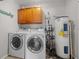 Functional laundry room with washer, dryer, and overhead cabinets at 17175 Ne Jacksonville Rd, Citra, FL 32113