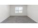 Spacious bedroom featuring grey carpet and a window with blinds at 27 Hickory Course Ln, Ocala, FL 34472