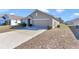 Front view of a single-story house with a garage and driveway at 27 Hickory Course Ln, Ocala, FL 34472