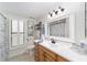 Updated bathroom with wood vanity, white tile, and shower at 5041 County Road 114, Wildwood, FL 34785