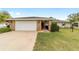 Single story home with a 2-car garage, stone accents, and a well-maintained lawn at 5041 County Road 114, Wildwood, FL 34785