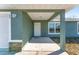 Covered front porch with stone accents and a white door at 53 Guava Pl, Ocklawaha, FL 32179