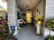 Inviting front porch with yellow door and potted sunflowers at 6082 Sw 104Th St, Ocala, FL 34476