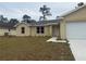 Tan one-story house with a white door and attached garage at 6189 Sw 134Th St, Ocala, FL 34473