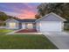 Gray house with white garage door, landscaping, and walkway at 66 Teak Loop, Ocala, FL 34472