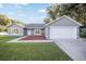 Gray house with white garage door, landscaping, and walkway at 66 Teak Loop, Ocala, FL 34472