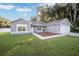 Gray house with white garage door, landscaping, and walkway at 66 Teak Loop, Ocala, FL 34472