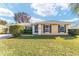 Tan house with green roof, landscaping, and a large yard at 73 Bahia Trace Crse, Ocala, FL 34472