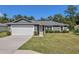 Gray house with white garage door and landscaped lawn at 753 Nw 63Rd Pl, Ocala, FL 34475