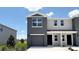 Stylish two-story home with a grey stucco facade, a garage, and a well-maintained front lawn at 8406 Gower Trl, Wildwood, FL 34785