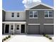 Contemporary townhome featuring a two-car garage, neutral paint scheme and a concrete driveway at 8410 Gower Trl, Wildwood, FL 34785