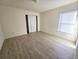 Simple bedroom with wood-look floors and window blinds at 8697 Se 136Th Ln, Summerfield, FL 34491