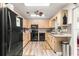 Galley kitchen with black appliances and wood cabinets at 8738 Sw 90Th St # B, Ocala, FL 34481