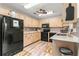 Galley kitchen with black appliances and wood cabinets at 8738 Sw 90Th St # B, Ocala, FL 34481