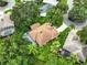 Aerial view of a home with landscaped property, a screened-in pool, and beautiful surrounding foliage at 8990 Se 178Th Muirfield Pl, The Villages, FL 32162