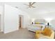Light and airy bedroom with neutral carpet, a whitewashed bed frame, and yellow accents at 8990 Se 178Th Muirfield Pl, The Villages, FL 32162