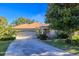 Tan one-story house with a two-car garage and landscaped yard at 8990 Se 178Th Muirfield Pl, The Villages, FL 32162