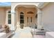 Inviting front porch features comfortable seating, decorative plants, and an elegant arched entryway at 8990 Se 178Th Muirfield Pl, The Villages, FL 32162