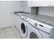 Bright laundry room, features washer, dryer, and ample counter space at 8990 Se 178Th Muirfield Pl, The Villages, FL 32162