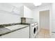 Clean laundry room featuring granite countertops, shelving, a sink, and a view into the house at 8990 Se 178Th Muirfield Pl, The Villages, FL 32162