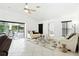 Bright living room boasts tile floors, a ceiling fan, and sliding glass doors to the patio at 8990 Se 178Th Muirfield Pl, The Villages, FL 32162
