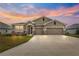 Two-story house with a three-car garage, stone accents and landscaping at 9181 Sw 49Th Ct, Ocala, FL 34476