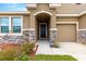 Front entrance with stone detailing, arched entryway, and a three-car garage at 9181 Sw 49Th Ct, Ocala, FL 34476